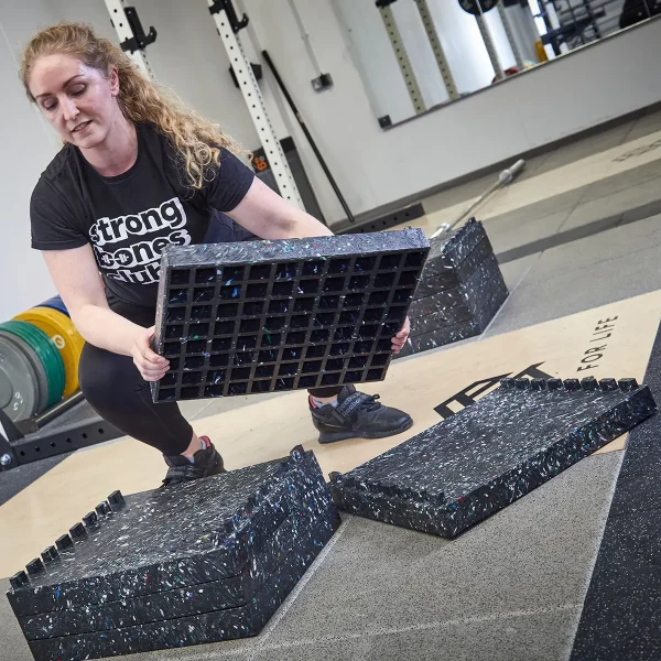 Woman stacking the interlocking DC blocks Original weightlifting blocks